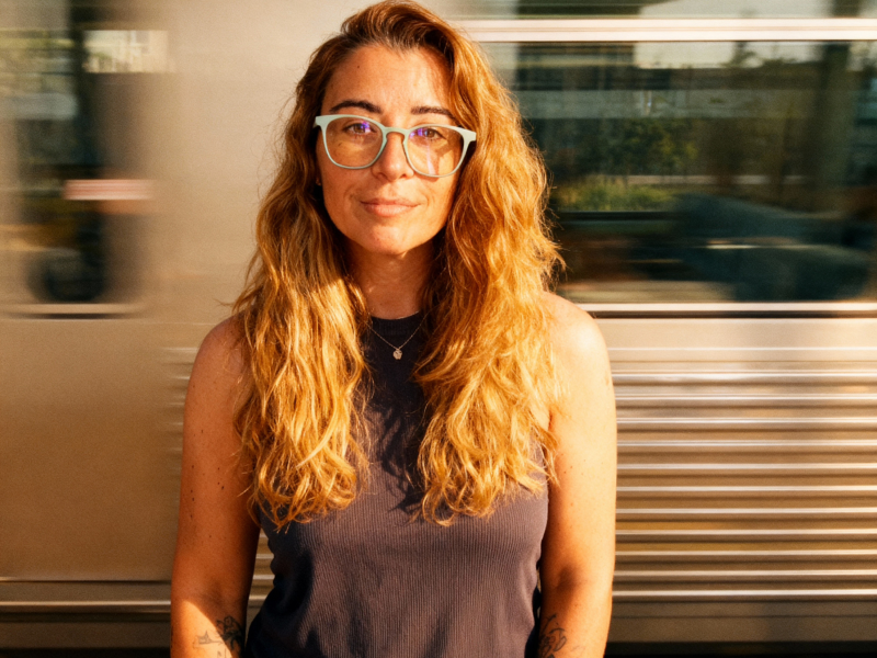 Laura on train station with a racing train in the background